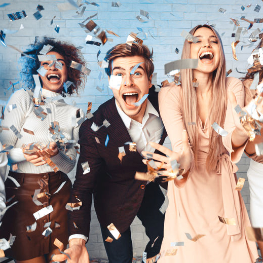 Great Party. Excited Young People Having Fun Under Falling Confetti Dancing And Shouting Celebrating New Year Indoor. Panorama